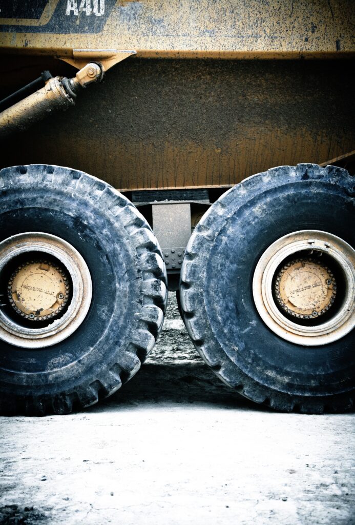 Transporte de maquinaria pesada en subasta siendo cargada en camión de Fletes USA, servicio de logística eficiente para envíos dentro de EE. UU. y hacia México y Canadá.