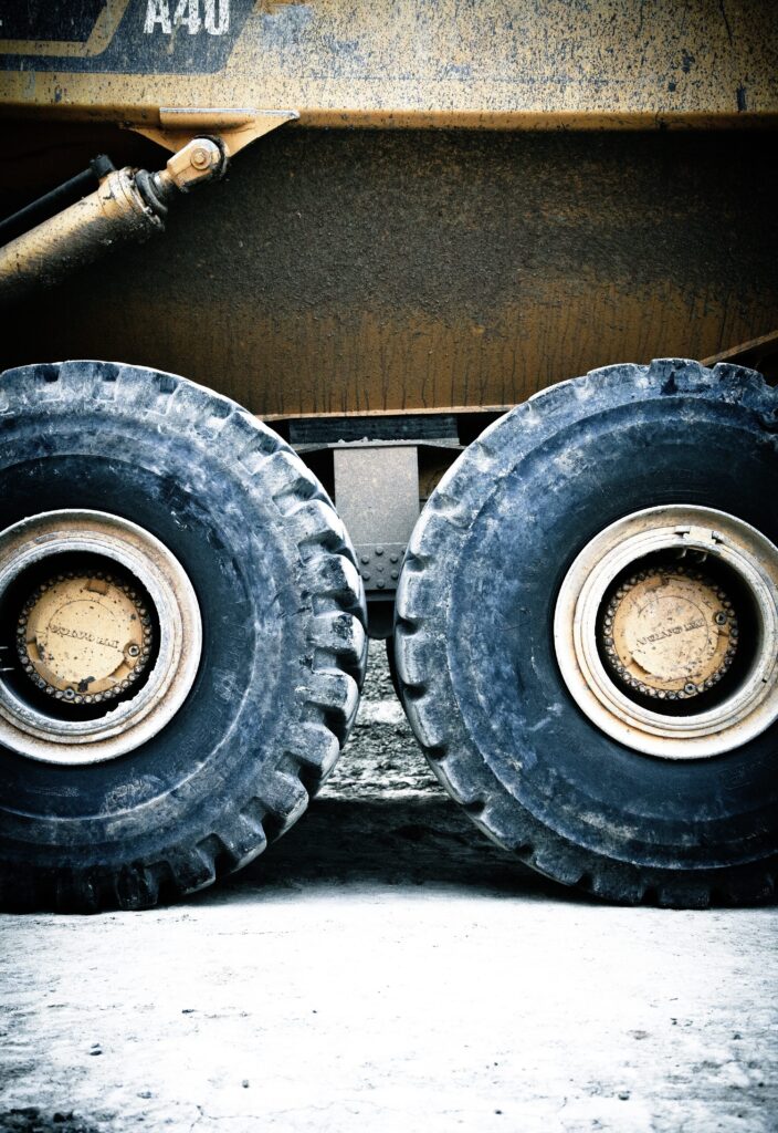 Transporte de maquinaria pesada en subasta siendo cargada en camión de Fletes USA, servicio de logística eficiente para envíos dentro de EE. UU. y hacia México y Canadá.